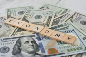 Global economy concept with US dollar bills and wooden letter tiles spelling the word economy, representing financial growth in 2025.
