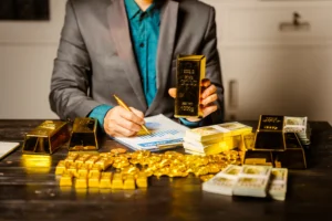 An investor holding gold bars and reviewing financial charts, representing the best gold stocks in the world for 2026 investment growth.