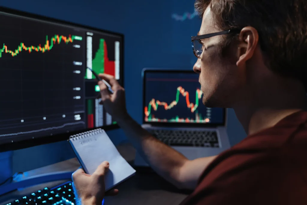 Trader analyzing charts on multiple screens while reviewing 24-Hour Volume Indicator data during market analysis.