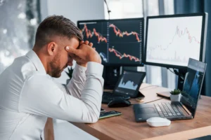 Forex trader stressed after making mitigation block mistakes while analyzing charts and liquidity grab patterns.