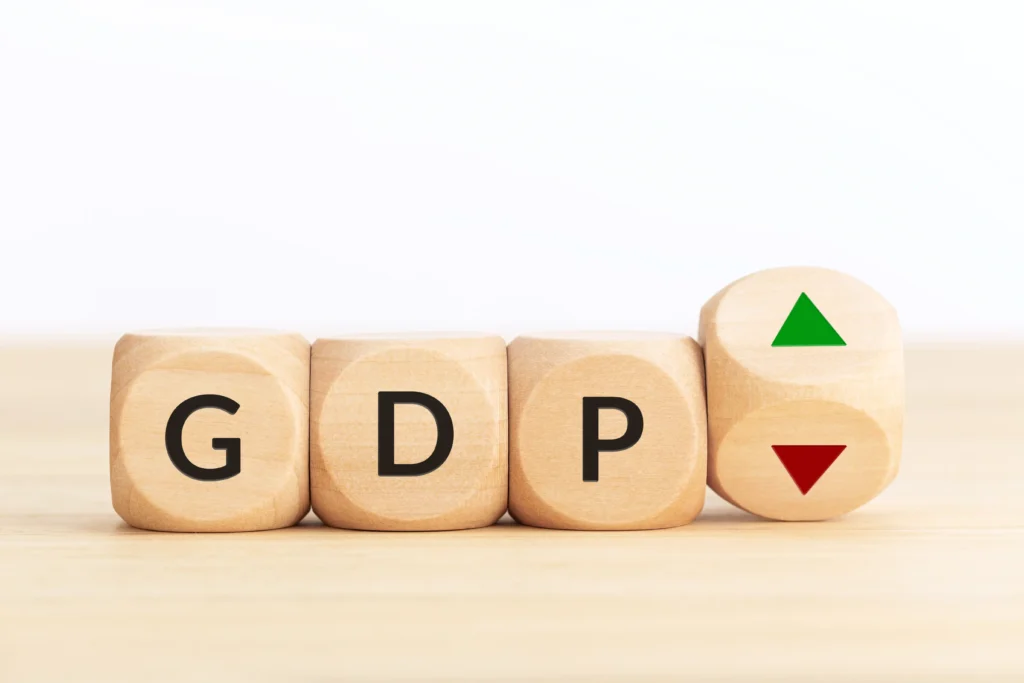 GDP report concept with wooden blocks showing GDP letters and economic up and down indicators.