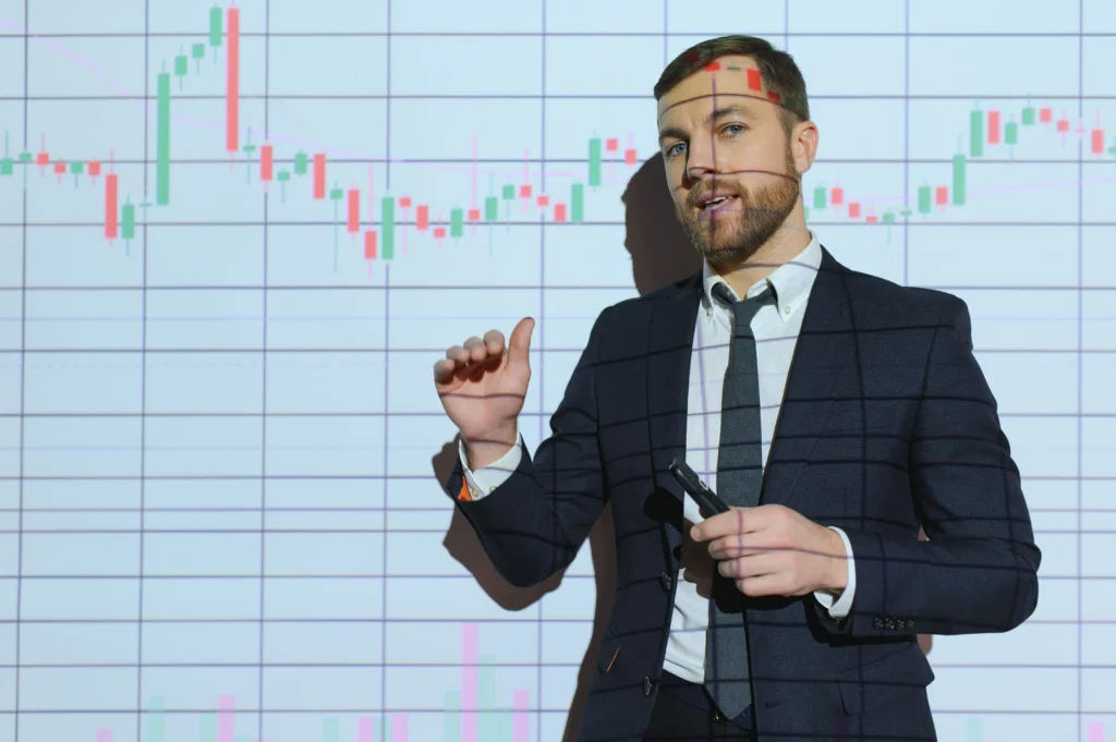 Professional trader explaining high-probability trading strategies in front of a candlestick chart.