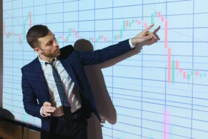 Business analyst explaining candlestick chart movement while highlighting an Opening Range Breakout setup on a large screen
