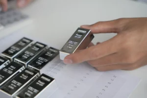 Silver bars being inspected by an investor during analysis of the 2026 Silver Export Ban market impact.