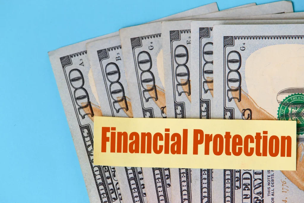 Stack of US hundred-dollar bills with a yellow label reading “Financial Protection,” symbolizing currency risk protection strategies.