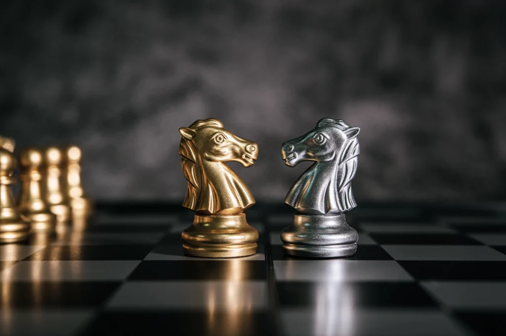 Gold and Silver 2026 outlook symbolized by metallic chess pieces on a chessboard representing strategic investment moves in precious metals.