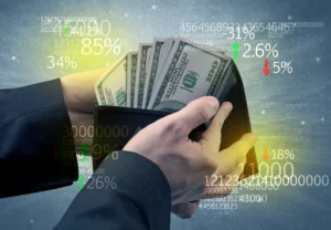 Hands holding a wallet full of US dollar bills with stock market data overlay, representing ETF and alternative investment growth in 2026.