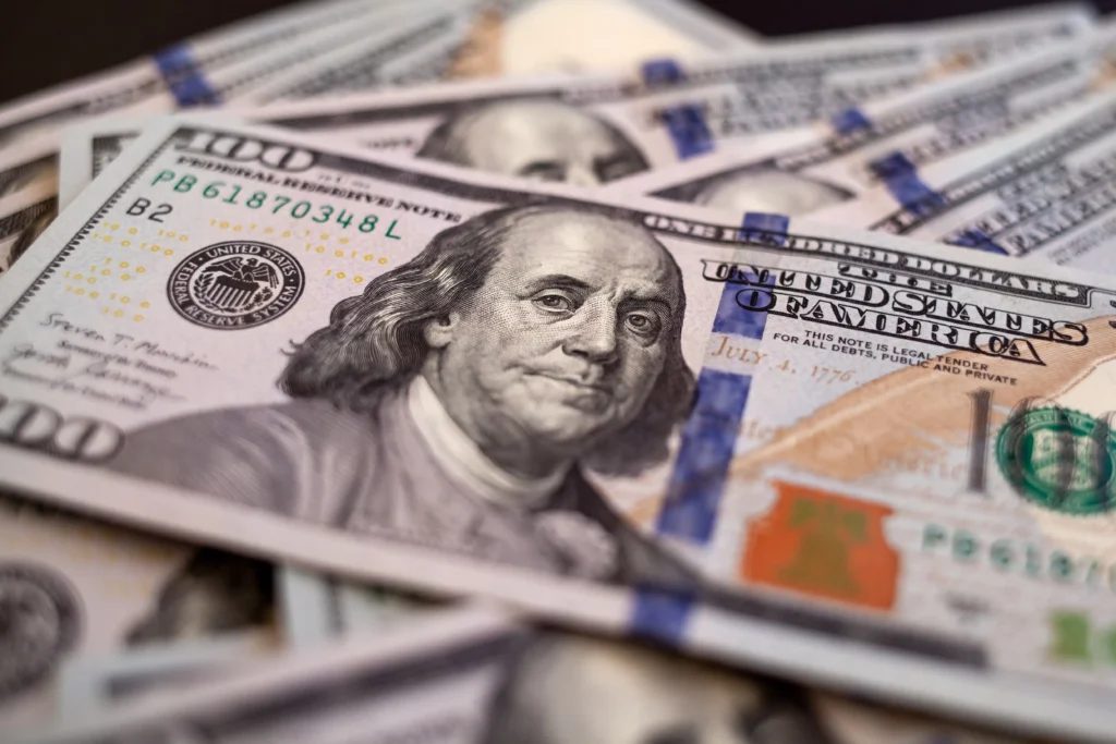 Dollar rises in 2026 — close-up of U.S. hundred-dollar bills symbolizing currency strength and renewed investor confidence.